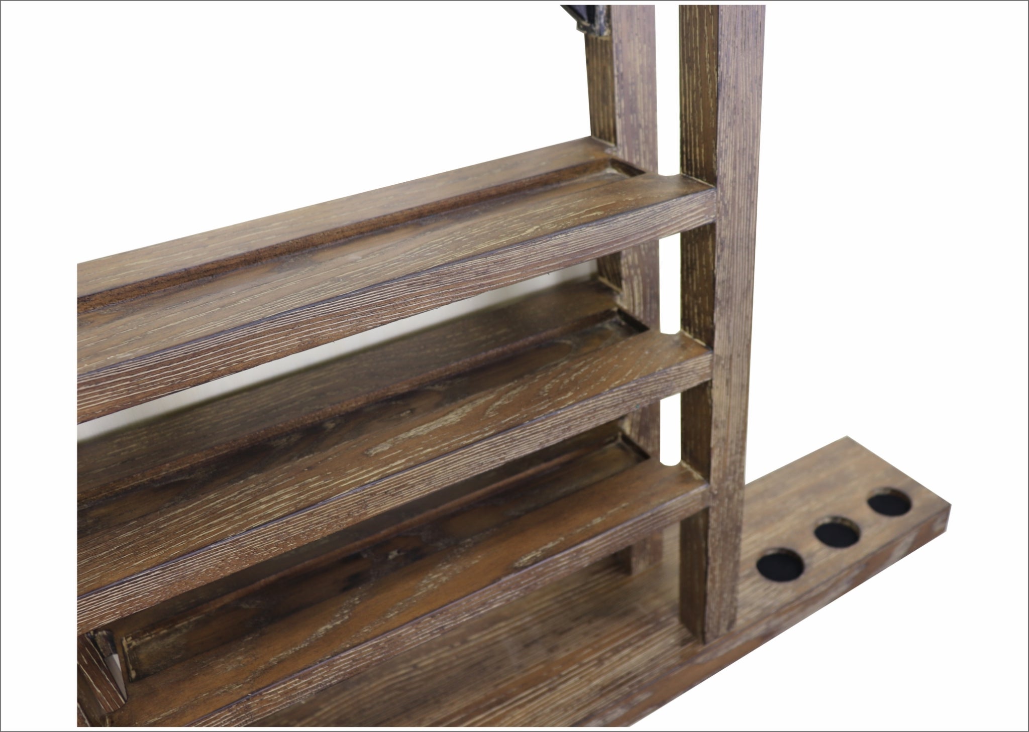 A closeup of the Nixon Hunter wall rack in a Brushed Walnut finish, focusing on the lower right side of the rack.
