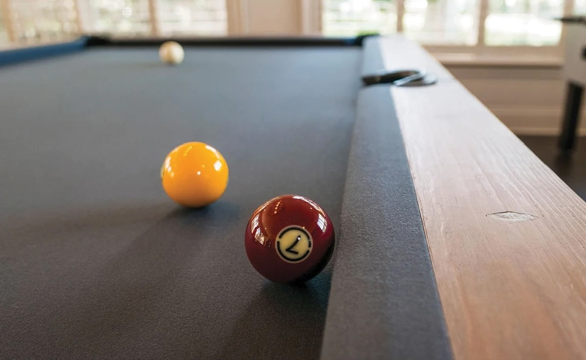 The Abbey slate pool table in an Antique Gray finish with gray felt. Designed by American Heritage.