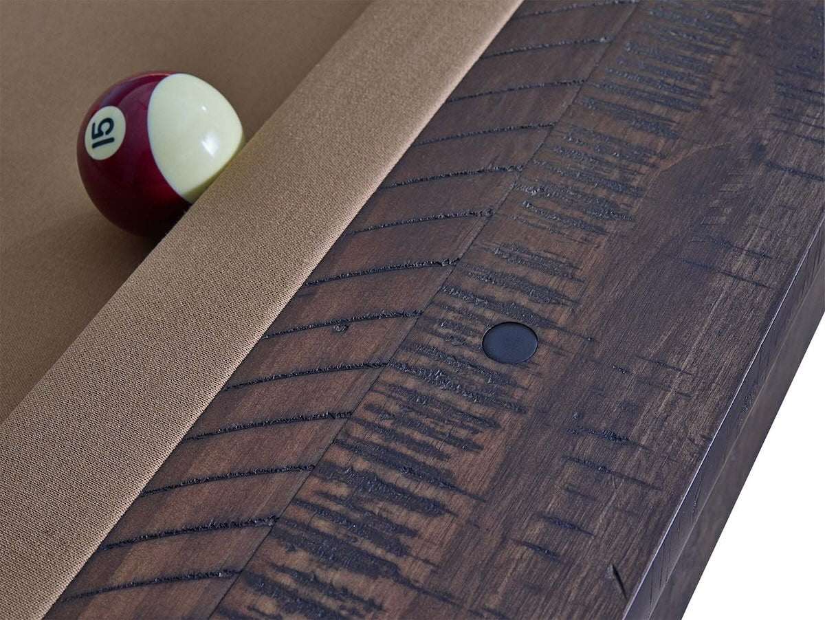 Close-up of the wood grain and one of the black rounded sights on the American Heritage Farmhouse billiard table.