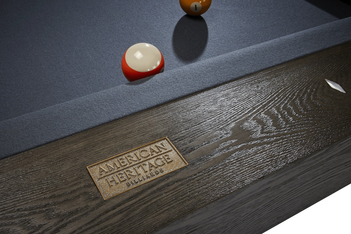 A close-up of the American Heritage logo on a Halifax pool table in a Charcoal finish.