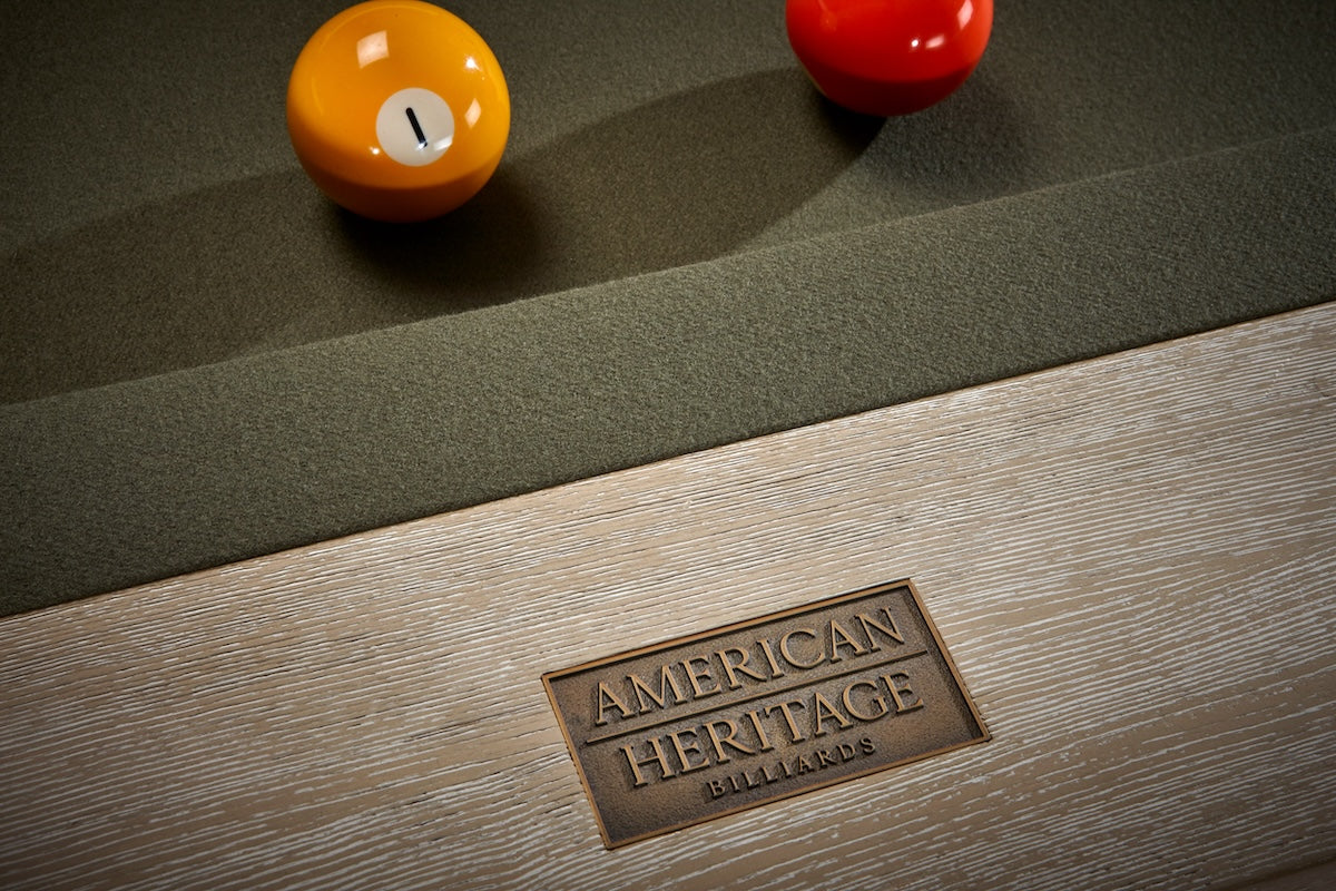 Close-up on the American Heritage logo on a Vancouver slate pool table with a Natural Ash finish.