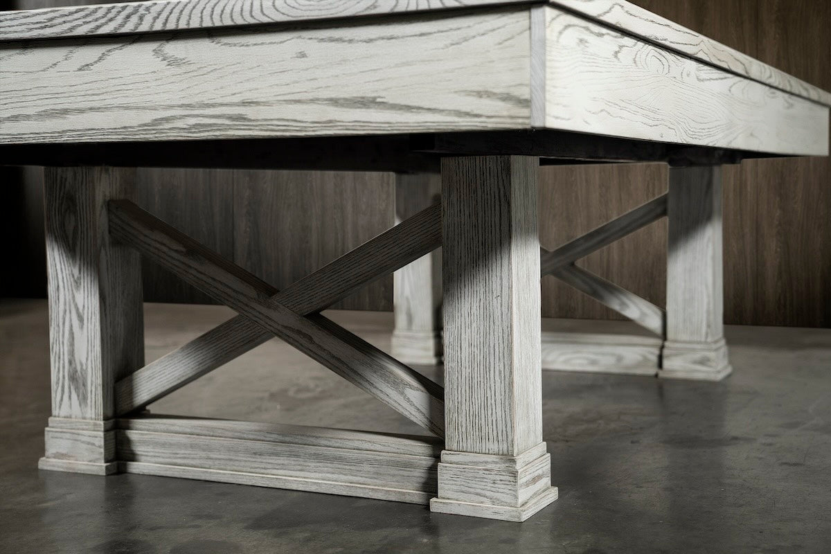 Two wood beams form an X between two legs of the Agriturismo pool table.