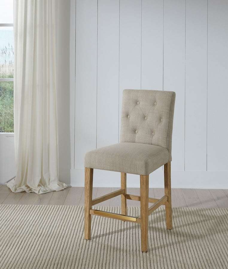 Port Royal Counter Height Stool with white oak finish, beige linen upholstery, tufted backrest, and wooden legs with footrest.