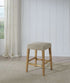 Port Royal Backless Stool with white oak finish, Sahara Sand linen cushioned seat, and sturdy wooden legs with cross supports