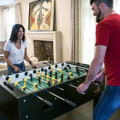 Couple playing the foosball with the Velcotiy Pro am foosball table by American Heritage.