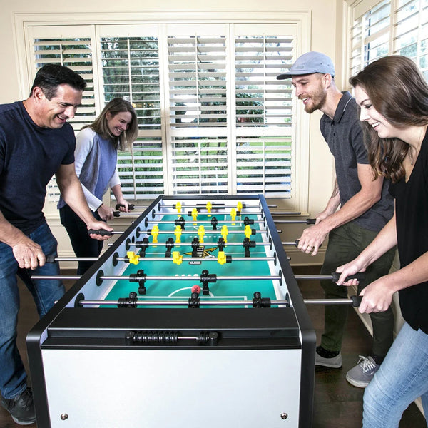 Four people play the American Heritage Velocity foosball table in Silver finish.