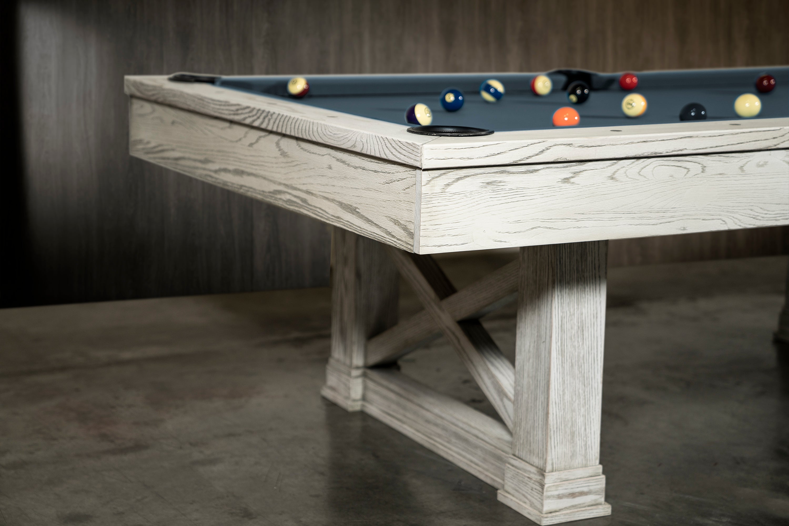 A closeup of a corner of the Isabella Agriturismo slate pool table with billiard balls on the scattered on the table.