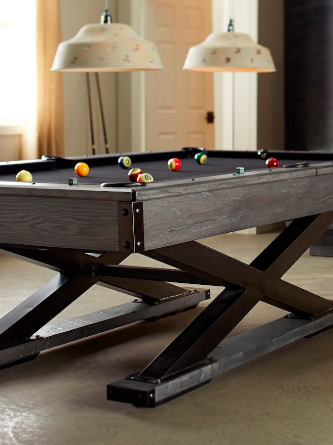The Quest slate pool table with a Glaicer finish and black felt color in a game room.