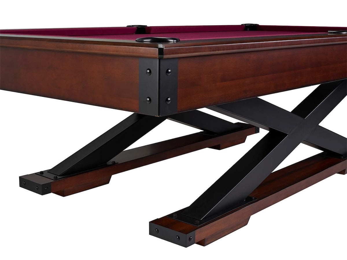Corner view of the Quest slate pool table by American Heritage with magenta felt color and a Navajo finish.