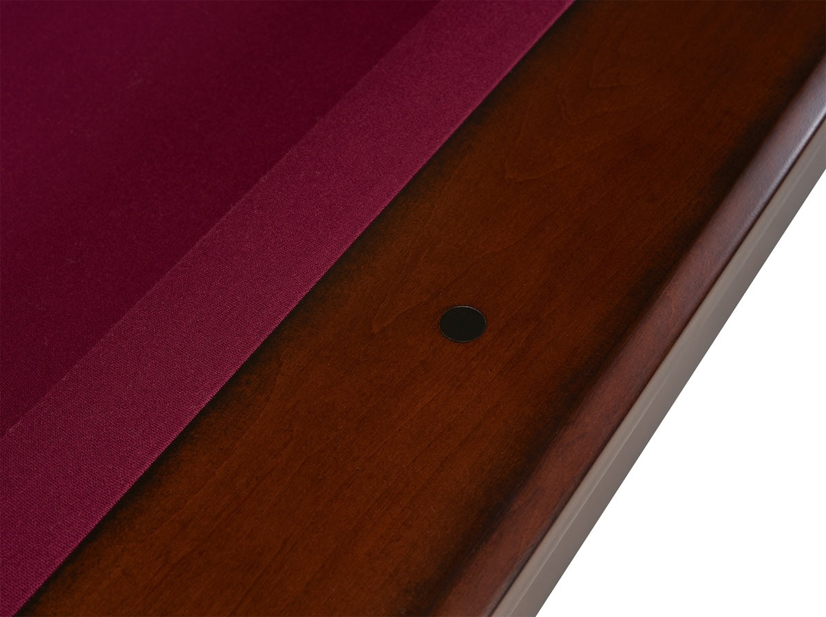 A closeup of one of the black round sights on a Quest pool table by American Heritage American Heritage in a Navajo finish.
