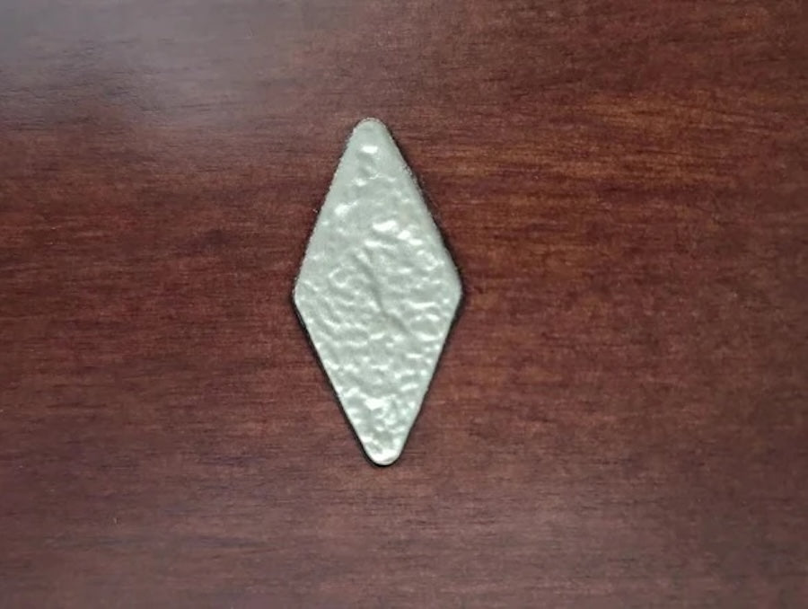 A closeup on one of the diamond-shaped sights on the Abbey slate pool table designed and manufactured by American Heritage.