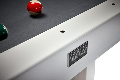 Close-up of the American Heritage logo on a Lanai slate pool table in Pearl White finish.